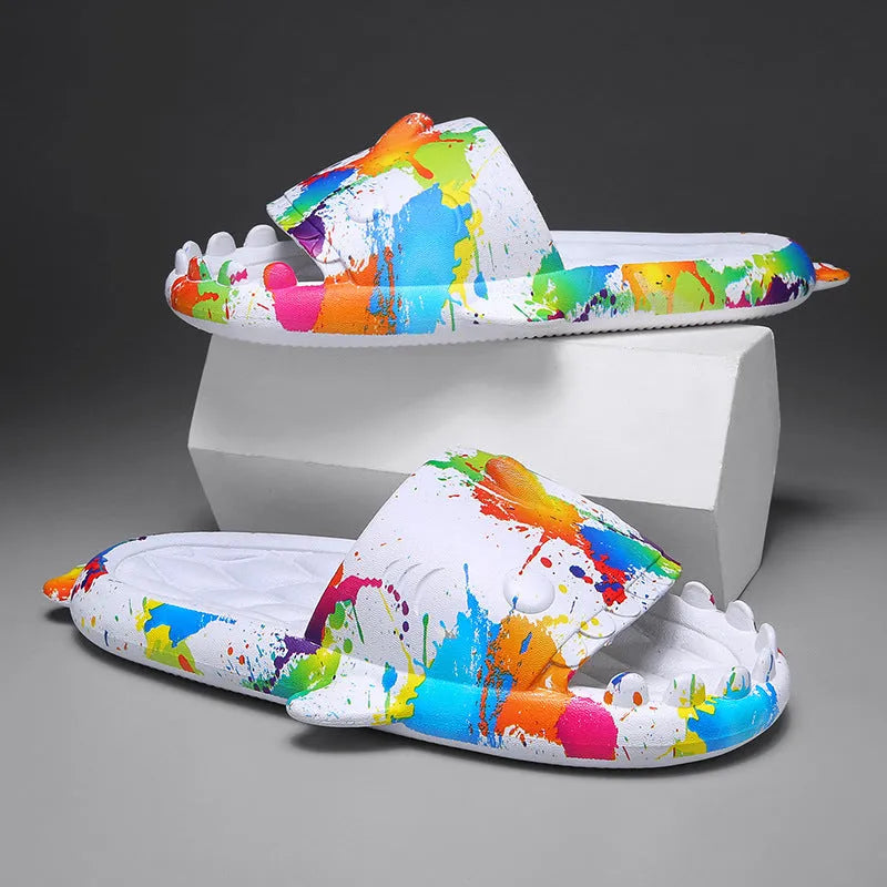 Cute shark design open toe EVA home slippers in assorted colours on a white background.