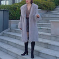 Grey women's thick faux rabbit fur mid-length coat with a fur collar on a hanger.