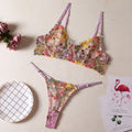Floral patterned mesh bra with steel ring detail on T-back strap, shown in skin colour.