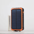Orange and green hand solar power bank with solar panel, hand crank, dual USB ports, and LED light
