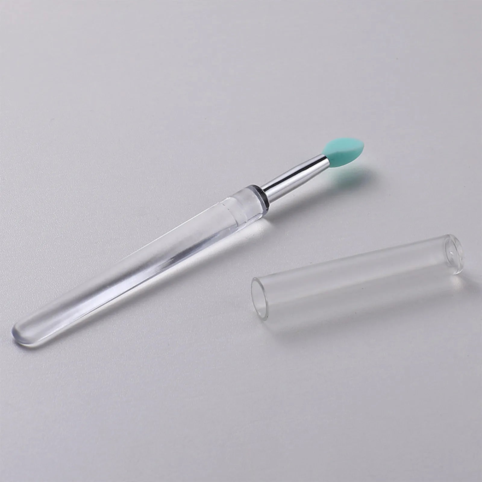 Set of coloured silicone lip brushes with protective caps for applying lipstick and lip gloss.