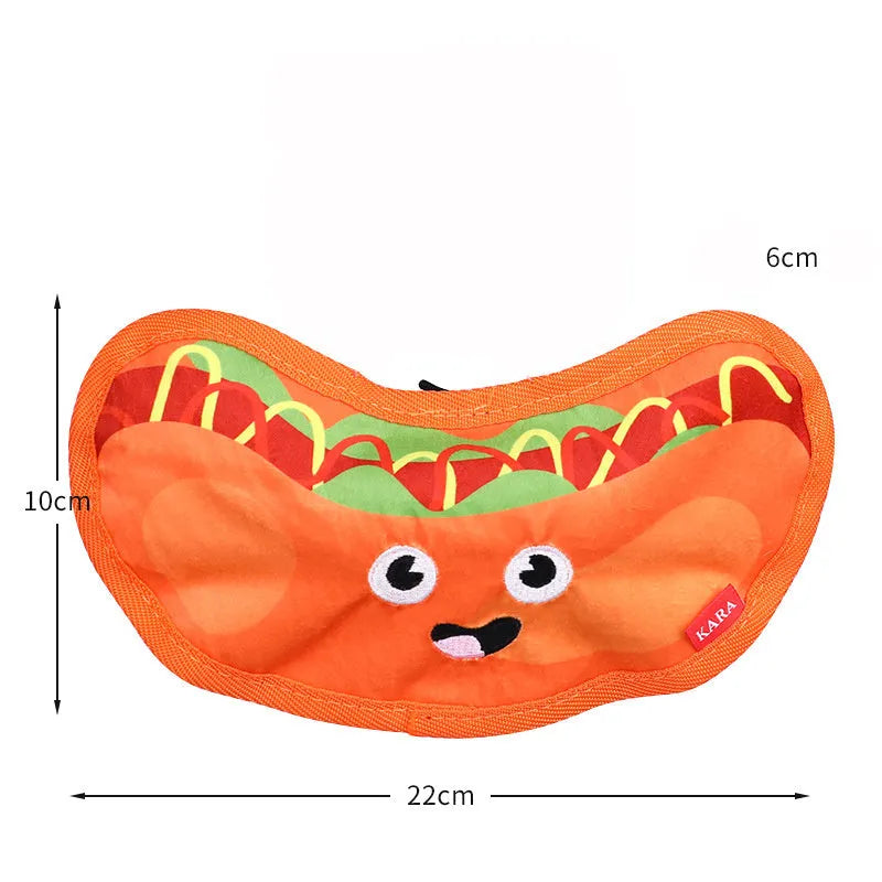 Colourful crinkle and squeaky dog chew toys shaped like a hamburger, fries, a hot dog, and a pizza on a plain background.