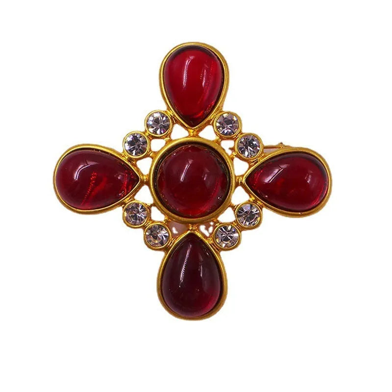 A vintage-style zinc alloy brooch with a baroque cross design and crystal accents.