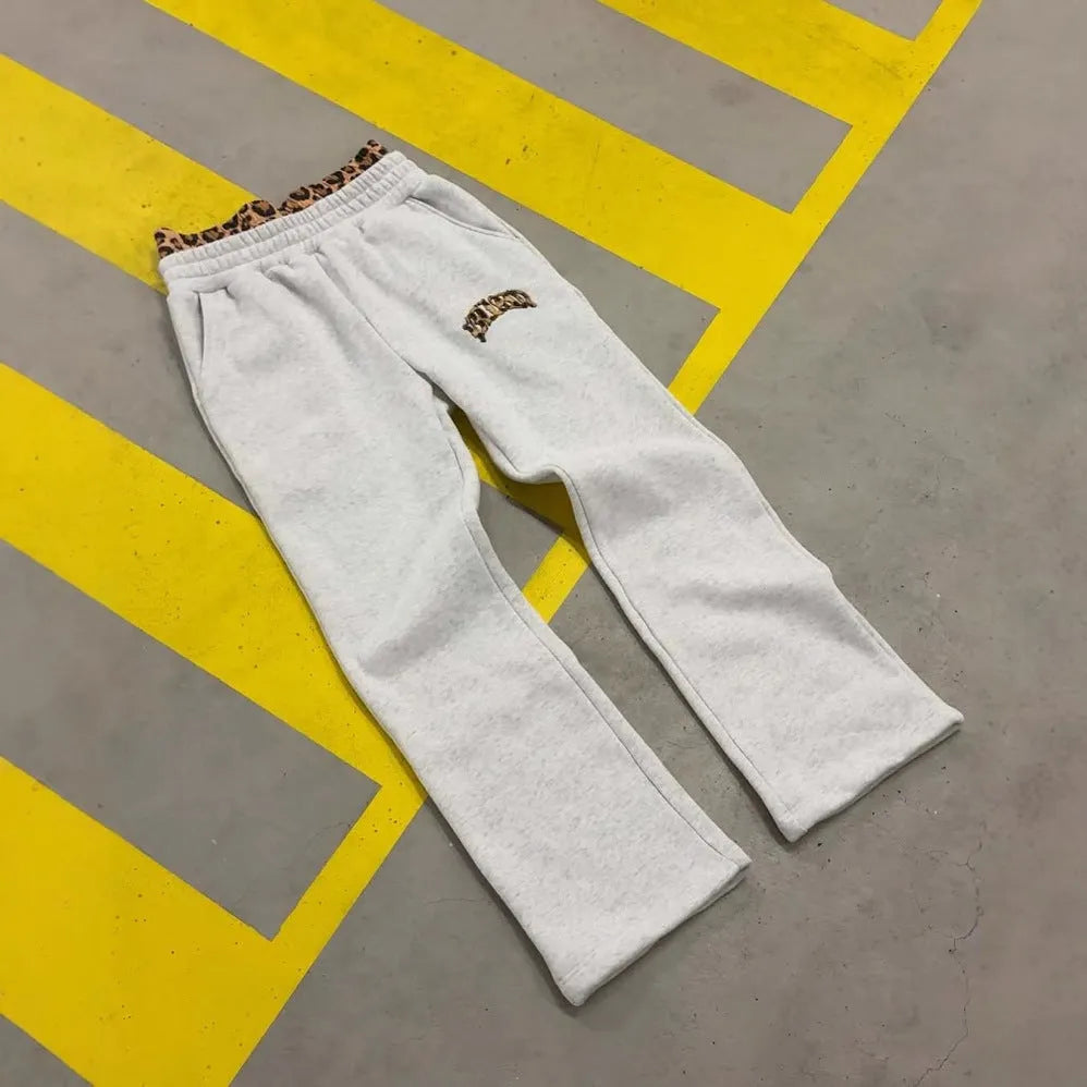 Men's loose grey patchwork double waist hip hop trousers on a plain background