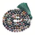 Long agate tassel necklace with geometric stone beads in various colours on a neutral background.