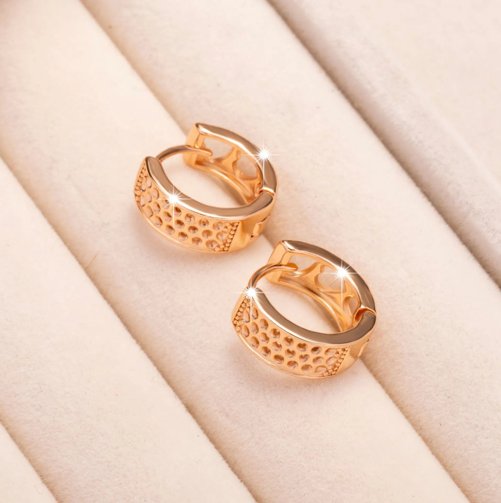 Rose gold electroplated women's earrings with three hollow heart designs in circular frame