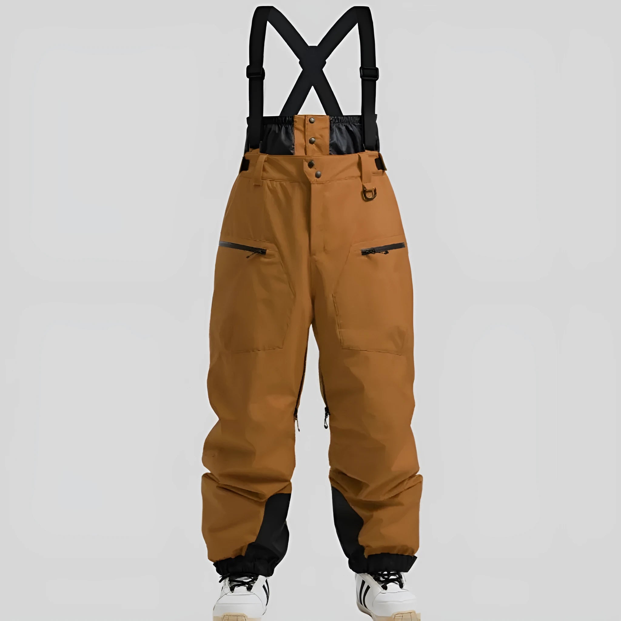 Man wearing black waterproof ski trousers with an adjustable strap on a snowy slope.