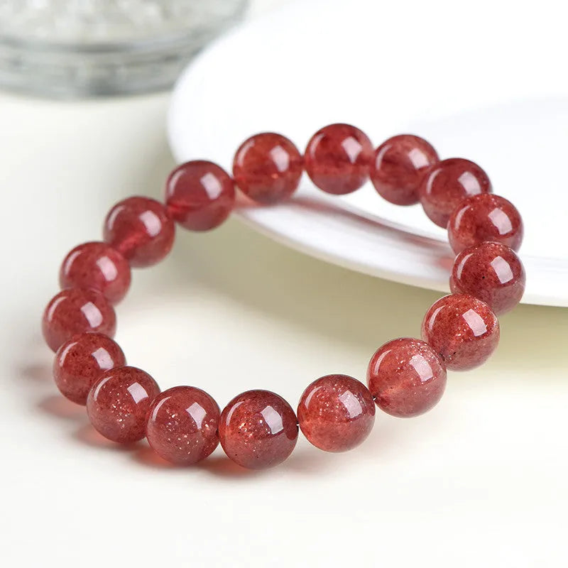 Natural cherry red strawberry quartz bracelet with geometry-shaped beads on a white background.