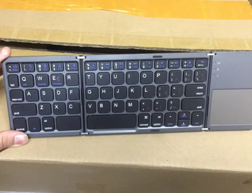 Black tri-fold folding Bluetooth keyboard with touchpad, shown both folded and unfolded.