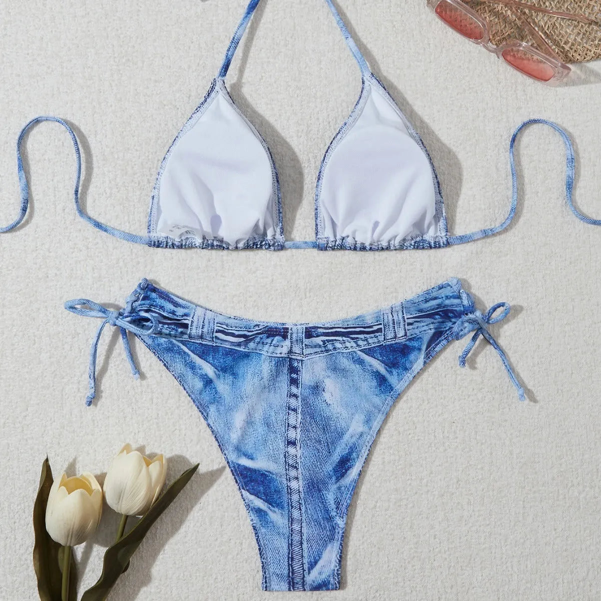 Women's denim blue printed bikini swimsuit with strap design on a hanger