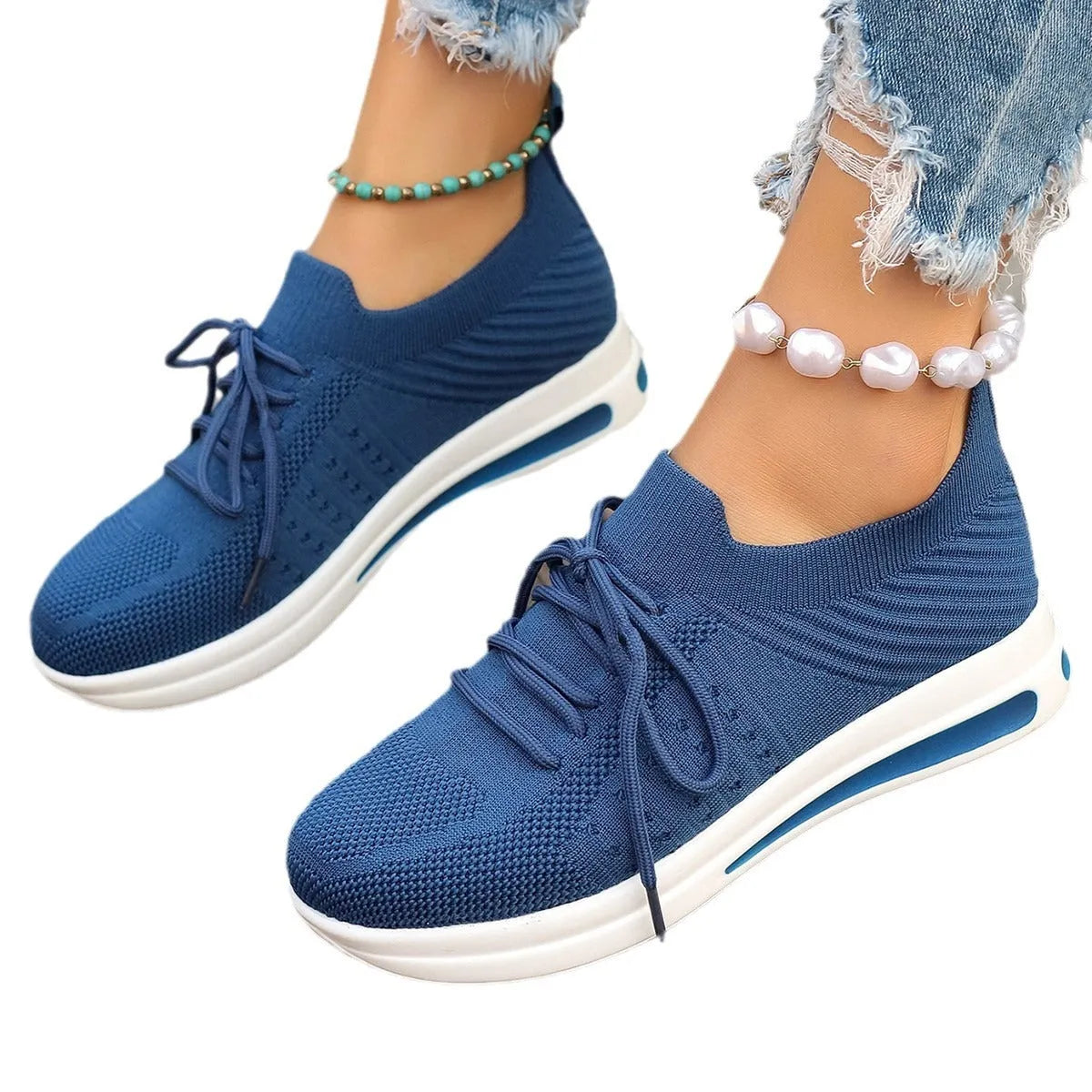 Women's low-top red fly-knit sneakers with round toe and white injection moulded sole on a light background.