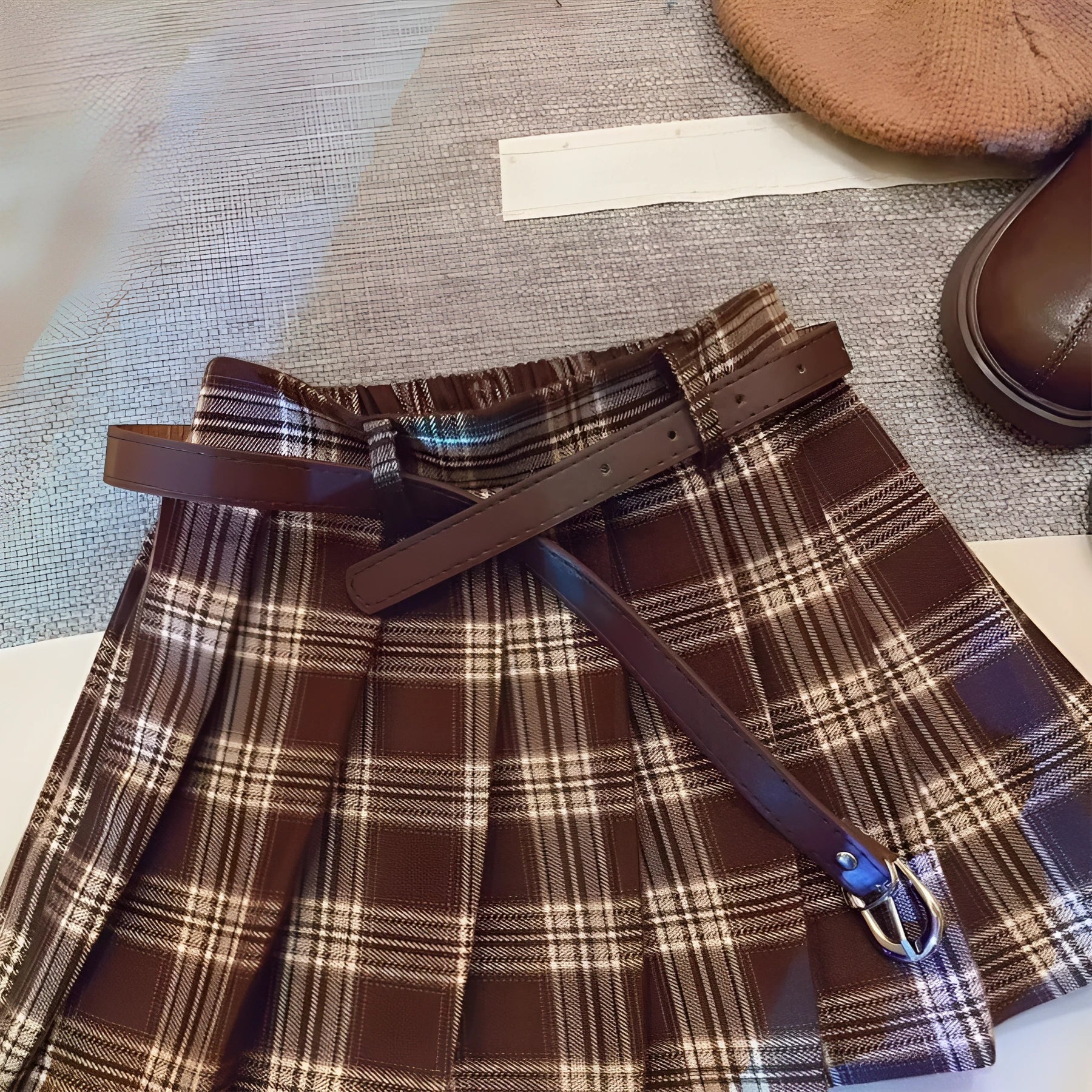 Girls plaid pattern pleated A-line skirt in cotton blend fabric on a hanger.