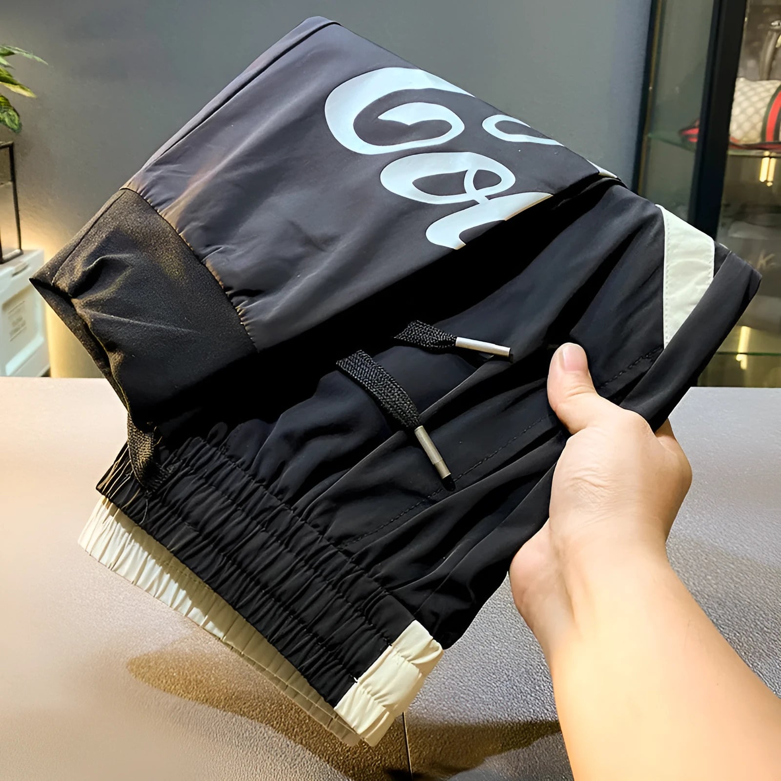 Black men's cropped casual trousers with ankle band, made from ice silk cotton fabric.