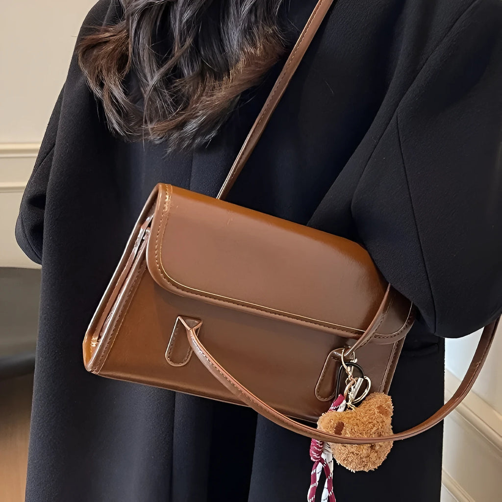 Brown women's PU leather shoulder bag with square shape, pendant detail, and double shoulder straps
