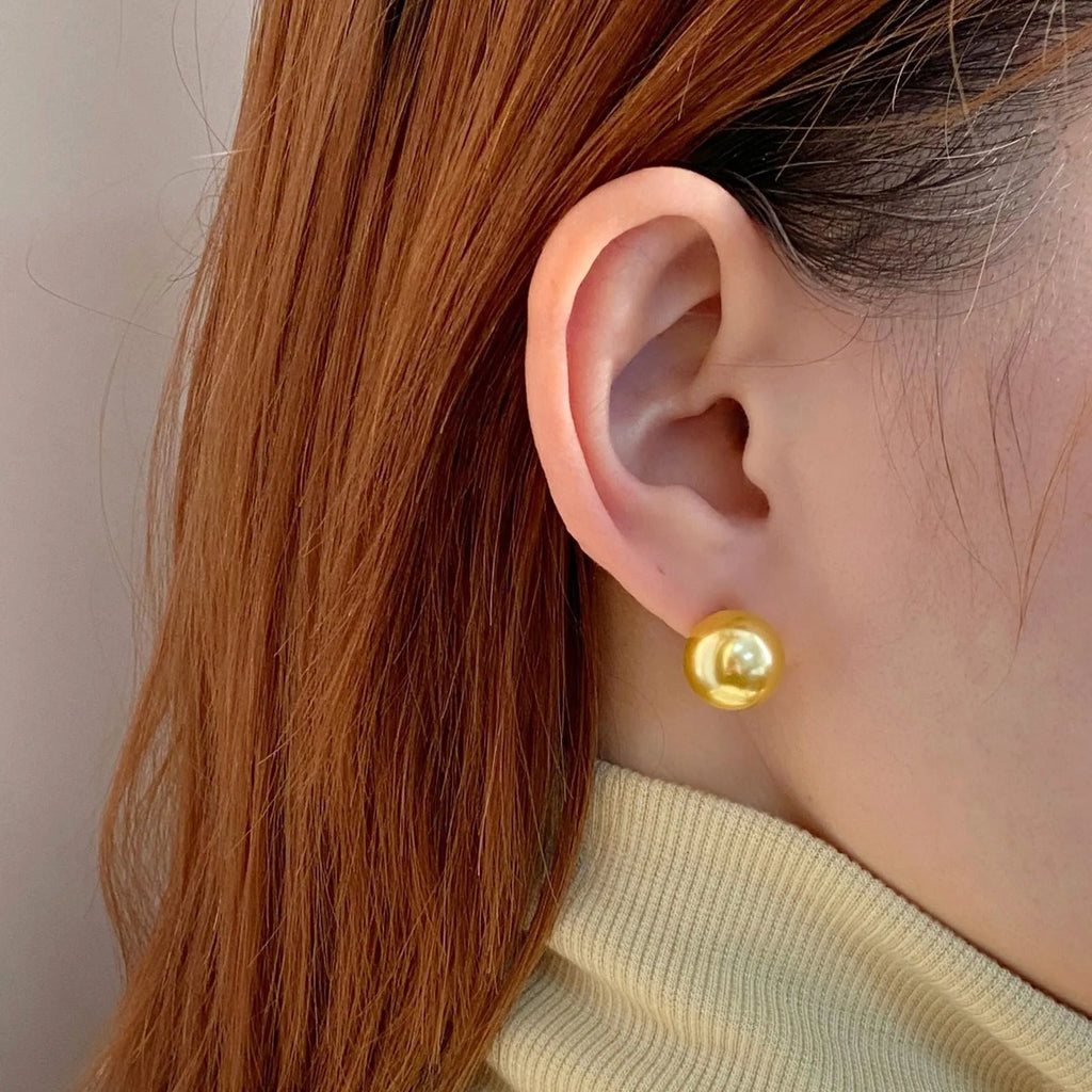 Geometric pearl stud earrings with an eight-point star setting, shown in silver.