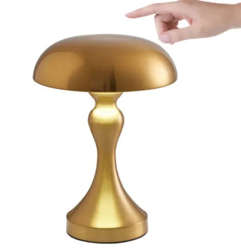 Metallic USB-rechargeable LED desk lamp with touch control for three light colours on a wooden desk.