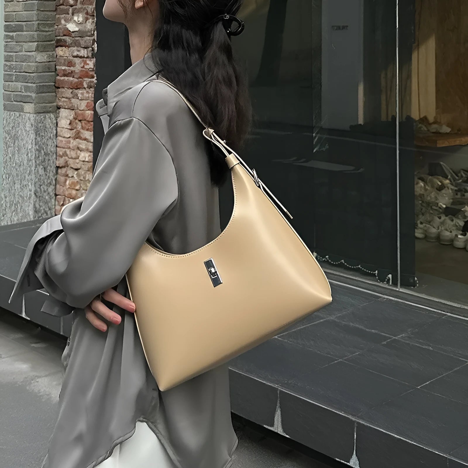 A soft genuine leather dumpling-shaped crossbody shoulder bag in a street style, shown with internal phone pocket.