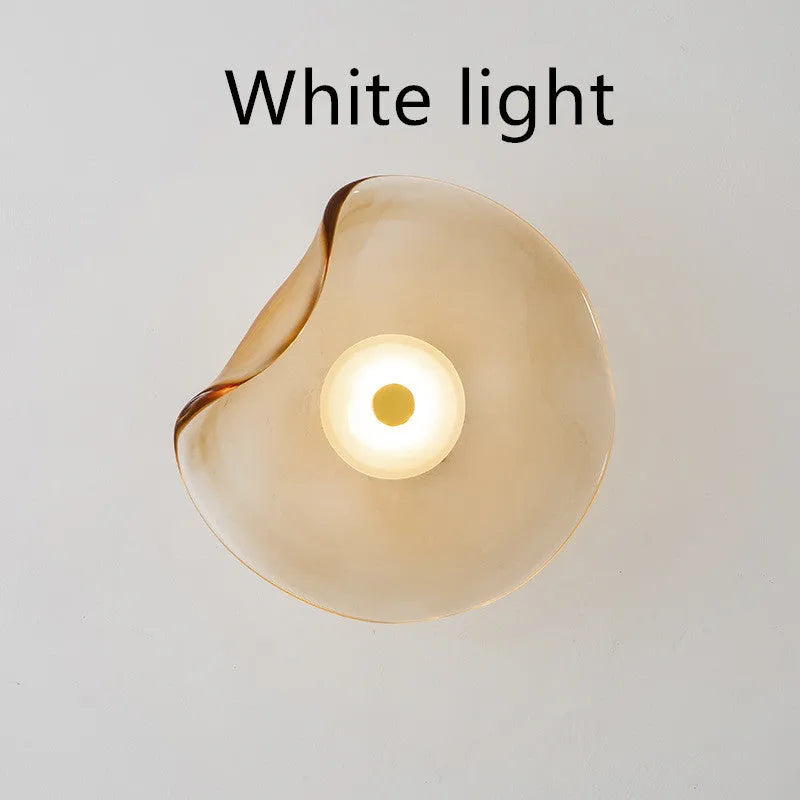 Round glass wall lamp for bedroom bedside in cognac, grey or light colour finishes.