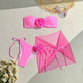 Women's pink swimsuit set with floral tube top, pants, and skirt for swimming.