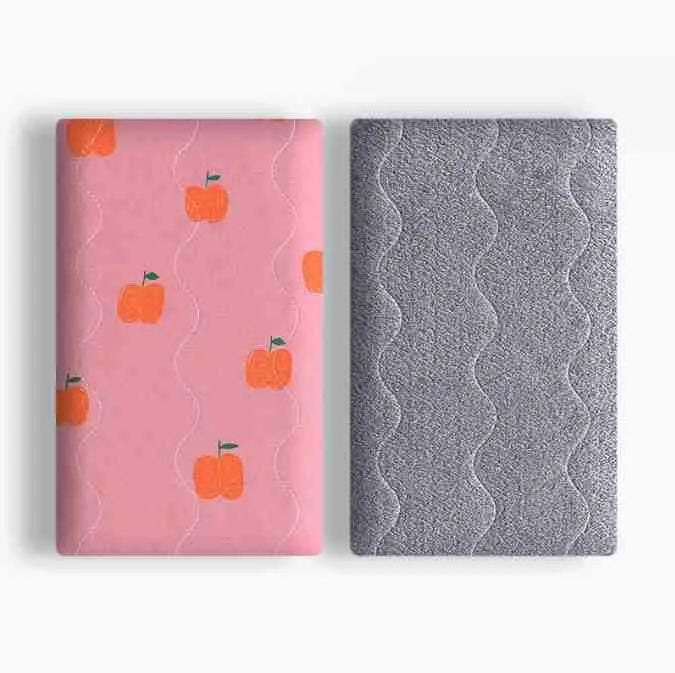 A soft cotton velvet pet blanket with a colourful dinosaur print, shown folded next to a dog bed.