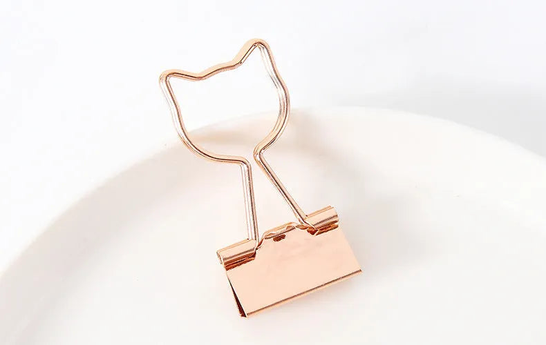 Gold long tail metal clip with decorative charm shape for document organisation