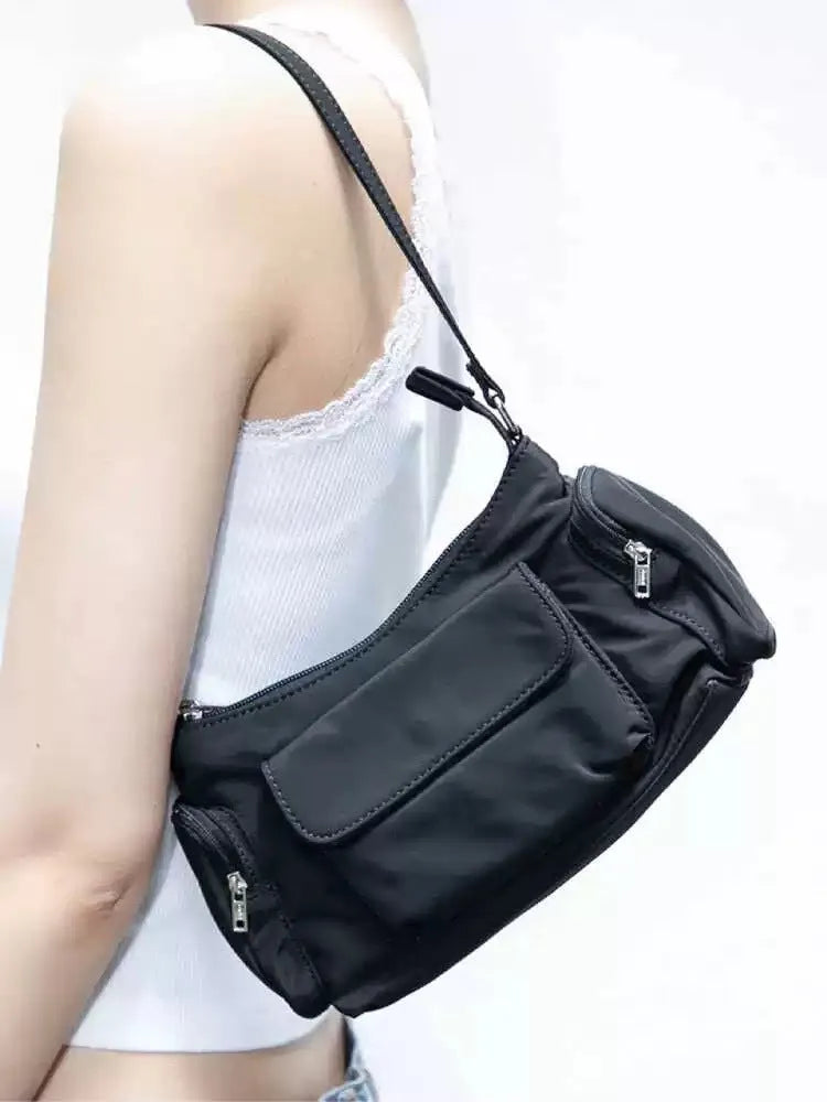 Black women's shoulder bag with two front pockets showing side line stitching detail