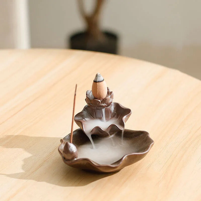 Square purple clay ceramic reverse flow incense burner with lotus and plum blossom decoration.