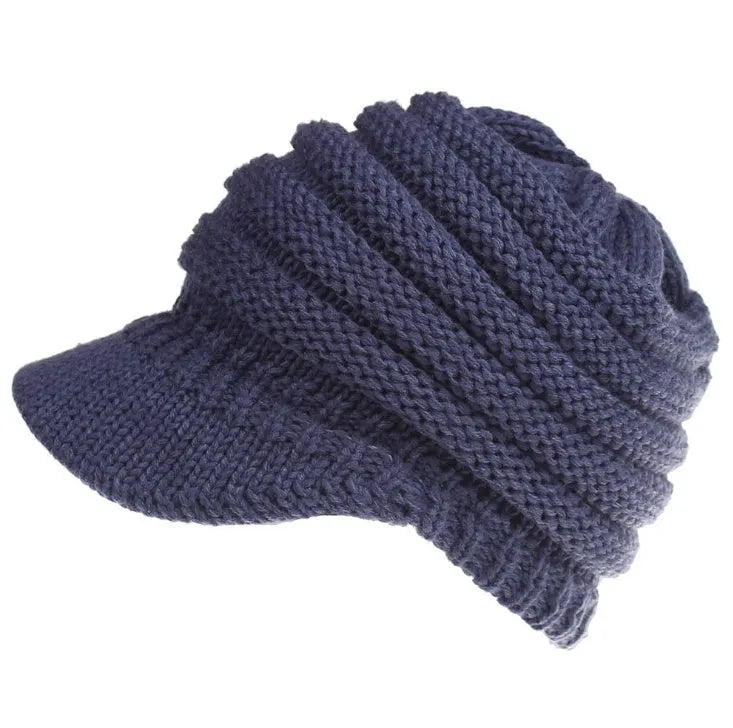 Woman wearing a soft knitted beanie with a ponytail pulled through the hole at the back.