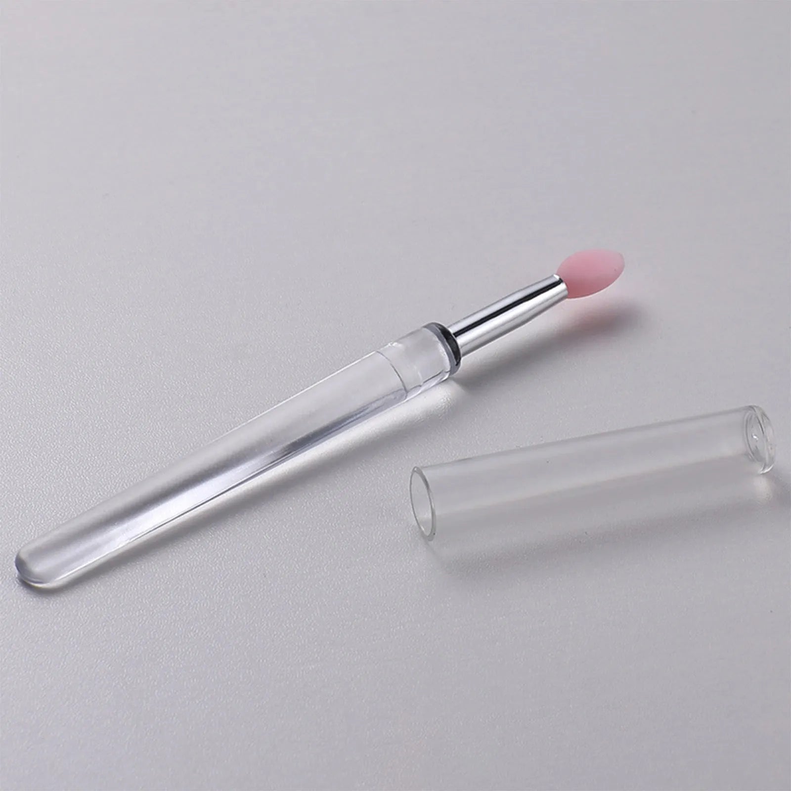 Set of coloured silicone lip brushes with protective caps for applying lipstick and lip gloss.