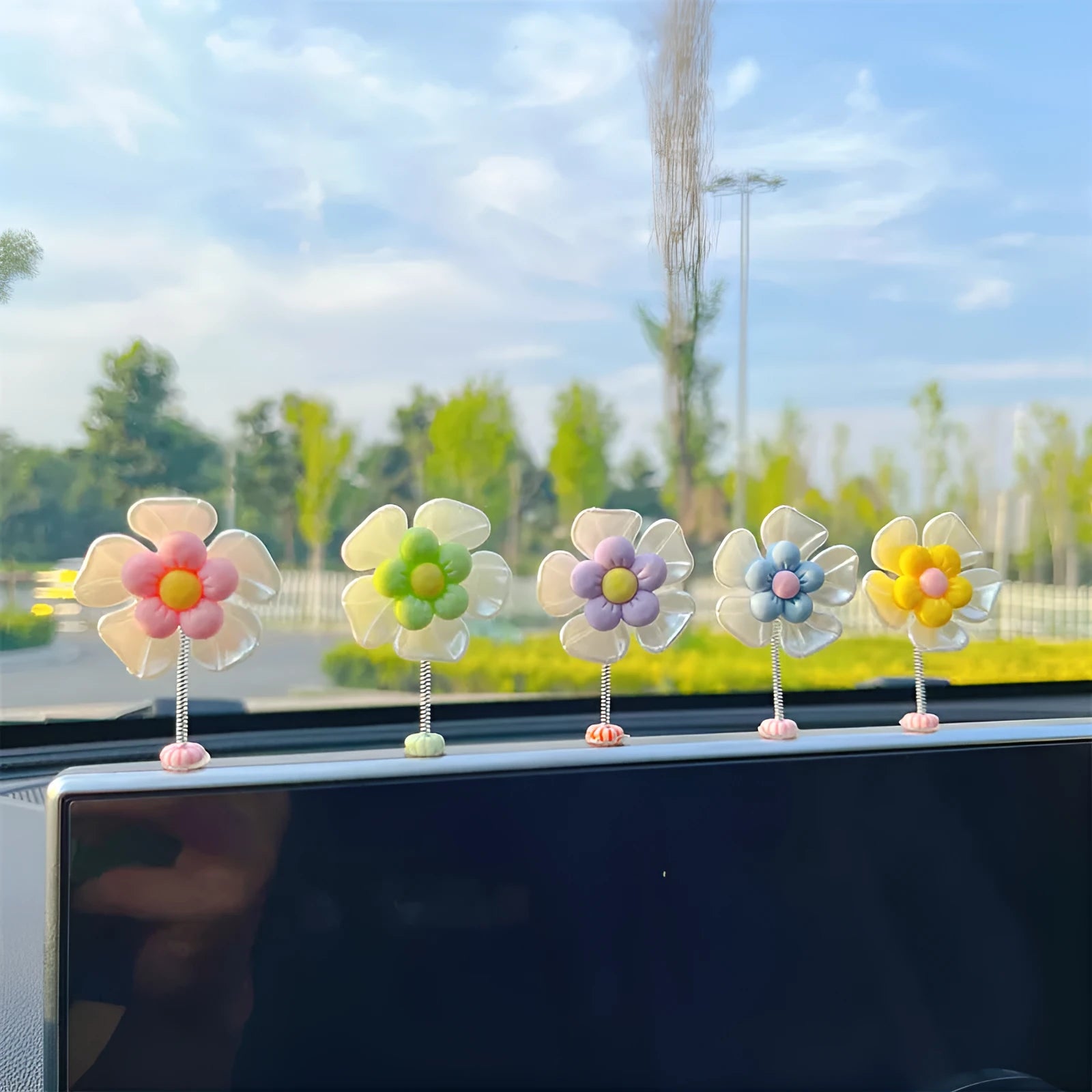 Small colourful plastic car swing decoration hanging from a rear-view mirror.