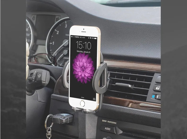Black plastic universal mobile phone holder attached to a car air vent.