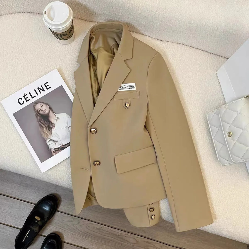 Black loose-fit women's short suit coat with front pockets on a hanger.