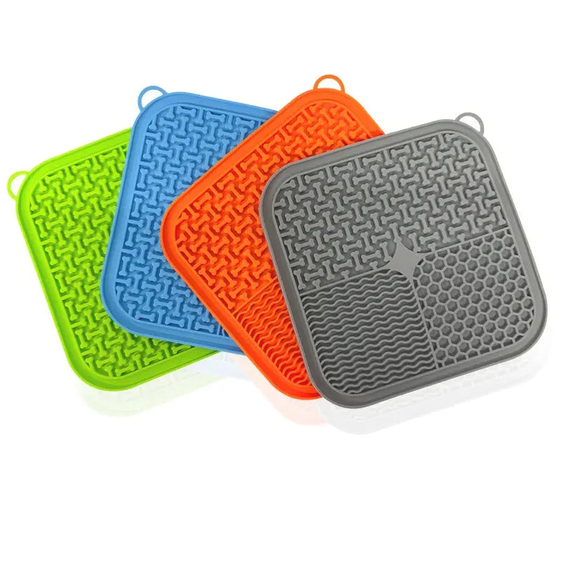 Blue silicone dog lick mat with textured surface and suction cups on back, shown on a tiled floor.