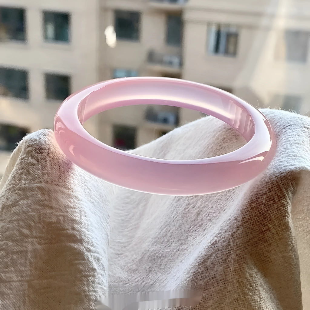 Natural agate wide tyre bracelet with cherry blossom jade accent on wrist, showing colour options.