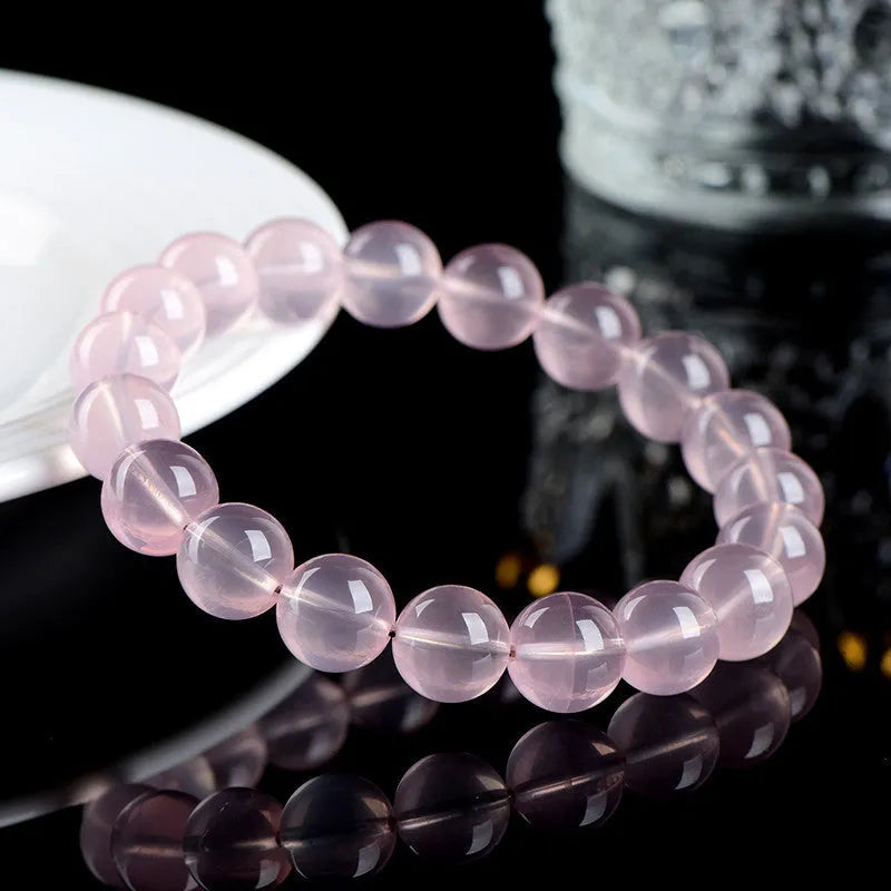 Women's natural style bracelet with round polished crystal beads in pink, showing size options from small to large beads.