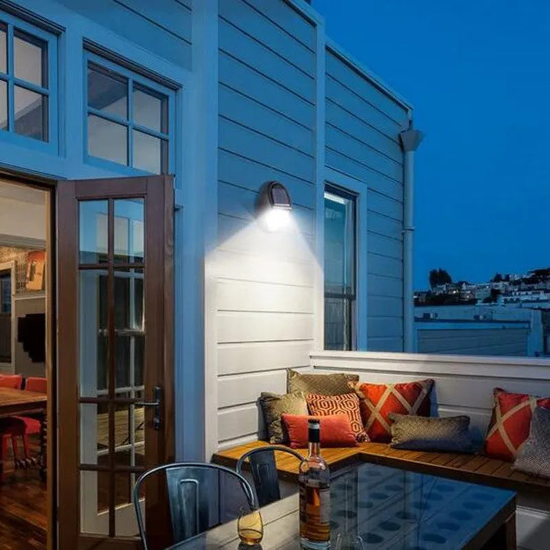 Black solar-powered LED wall light with solar panel and automatic activation