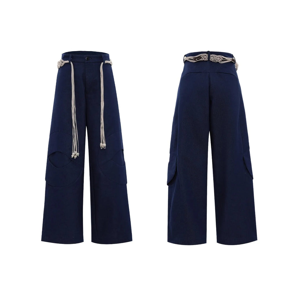 Man wearing dark blue straight-leg cotton jeans with heavy waistband stitching and decorative pocket details