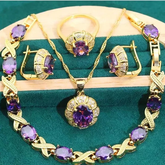 Gold coloured necklace, earrings, ring, and bracelet set with blue synthetic cubic zirconia stones.