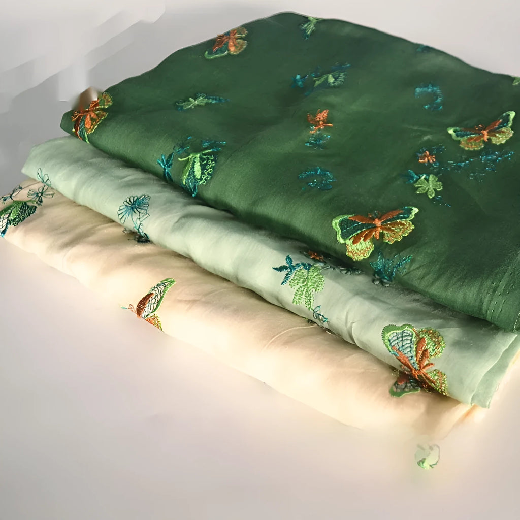 Roll of beige, grass green and dark green 100% ramie fabric for Hanfu sewing and embroidery, showing texture.