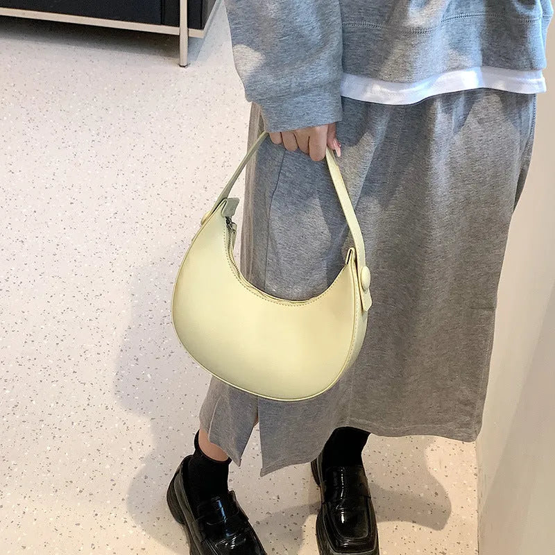 Women's retro brown dumpling-shaped PU shoulder bag showing front pocket and crossbody strap.