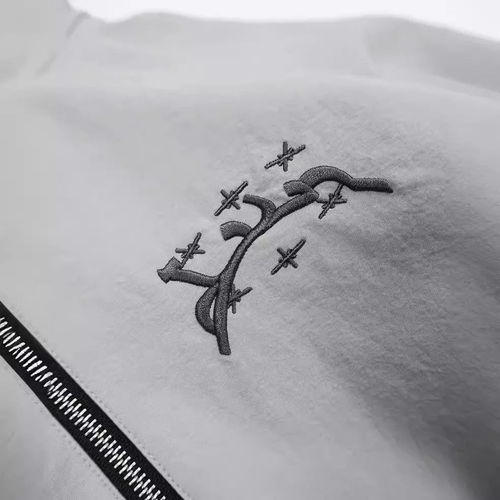 Grey loose-fit men's hooded sunscreen jacket in British style hanging on a hanger.