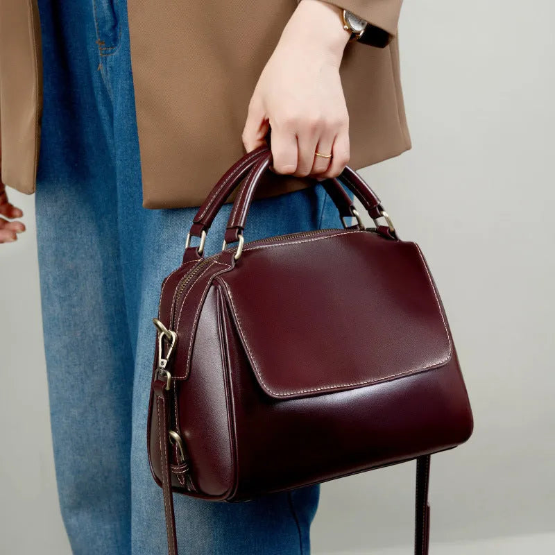 Women's genuine leather crossbody tote bag in apricot colour showing internal compartments and shoulder straps.