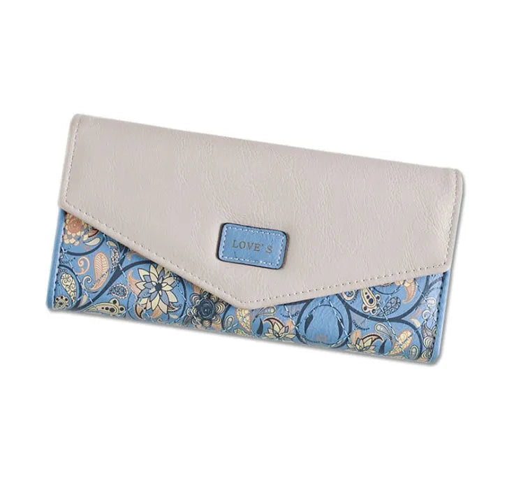 Women's black trifold leather wallet with buckle clip closure showing card slots and coin compartment
