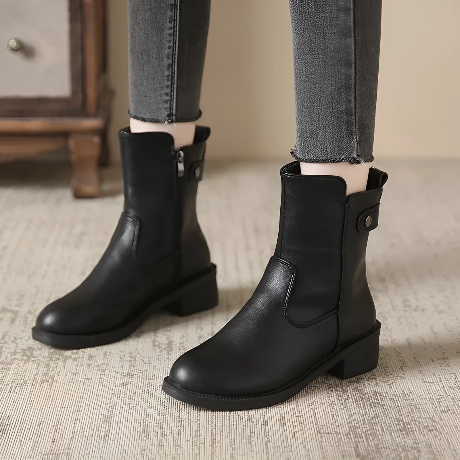 Black women's short boots with a low round toe and side zip, shown on a white background.