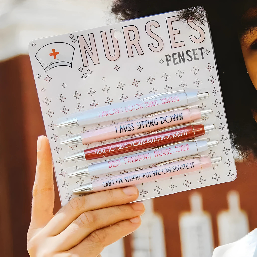Five nurse-themed retractable ballpoint pens laid out, showing humorous medical designs.