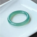 Natural agate wide tyre bracelet with cherry blossom jade accent on wrist, showing colour options.