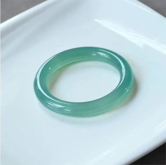 Natural agate wide tyre bracelet with cherry blossom jade accent on wrist, showing colour options.