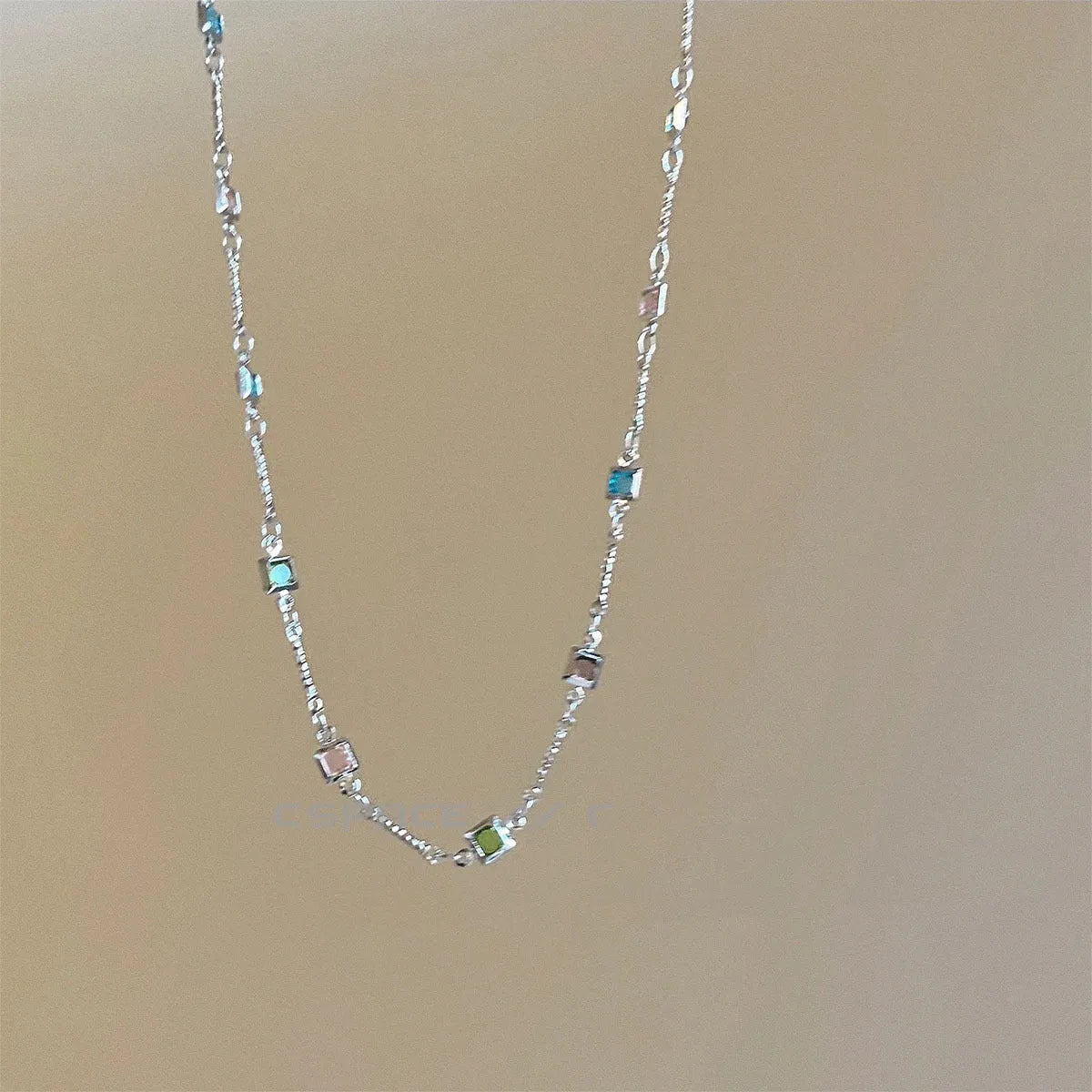 Fine gold-tone geometric necklace with a square clear crystal pendant on a clavicle-length chain.