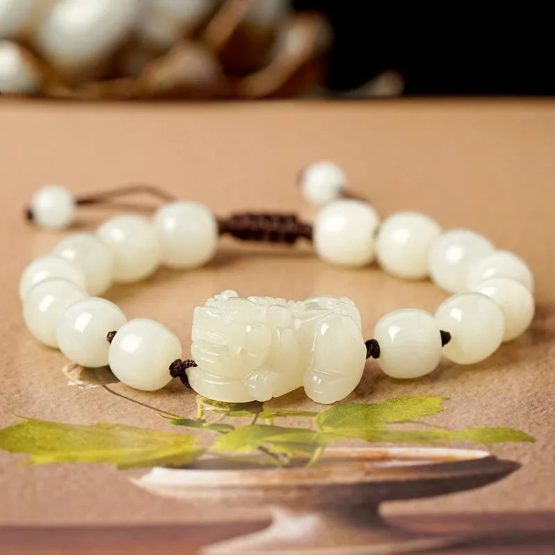 A Hetian jade bracelet with braided black and red rope in a Chinese style design.