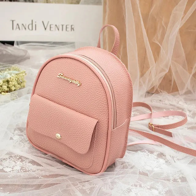 Small black PU shoulder backpack for women with zipper, shown next to a mobile phone for scale.